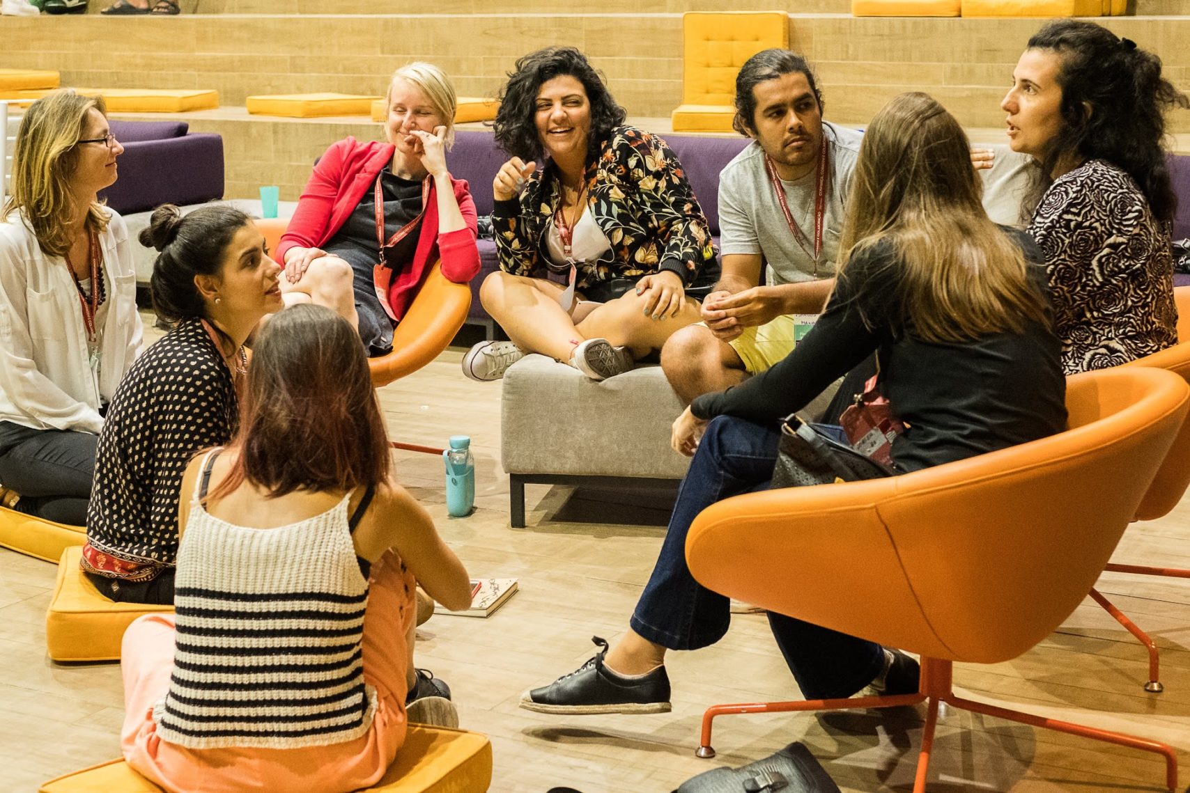 Impact Hub Slider Image with a group of people sitting down and talking with eachother