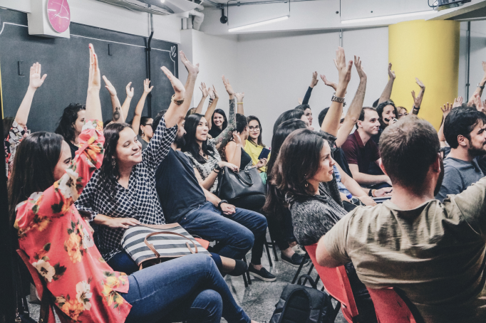 Young entrepreneurs raising hands in an event